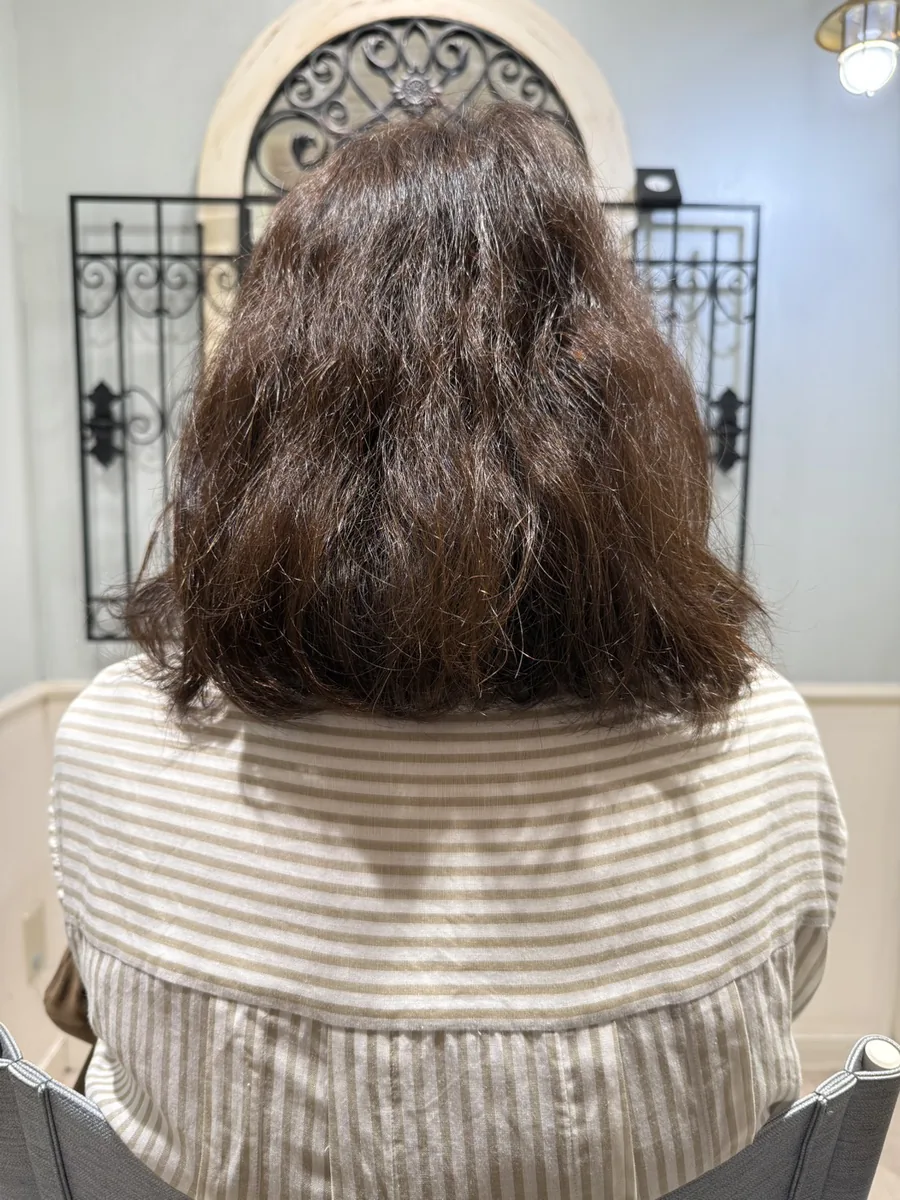 ビフォー。うねりで表面が毛羽立ち、毛先まで広がってしまうミディアムヘア。