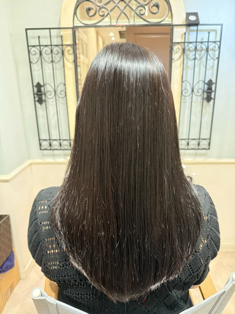 アフター。根元から毛先までまっすぐ整い、面の通った艶のあるロングヘア。