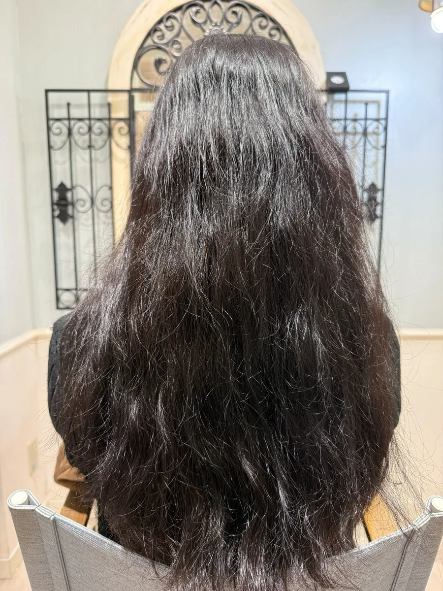 ビフォー。強いうねりと広がりで全体がふくらみ、表面がぼやけたロングヘア。